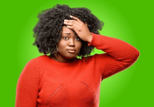 A woman in red sweater holding her head.